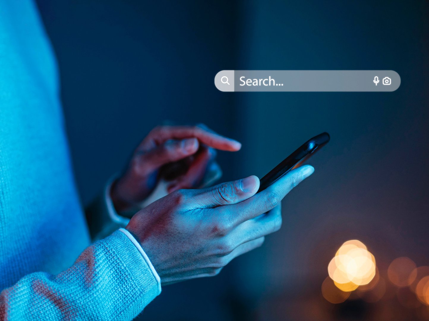 Hand som håller i en telefon och söker på Google
