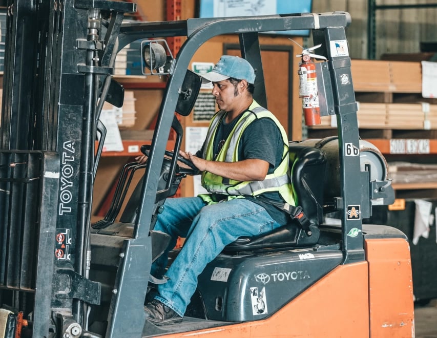 En mann sitter i en anleggsmaskin.