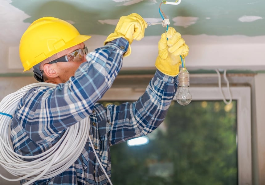 Elektriker fikser takbelysningen.