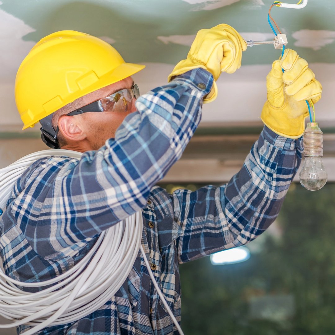 Elektriker setter opp en lampe.