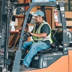 Mann som skanner pakker på lager.