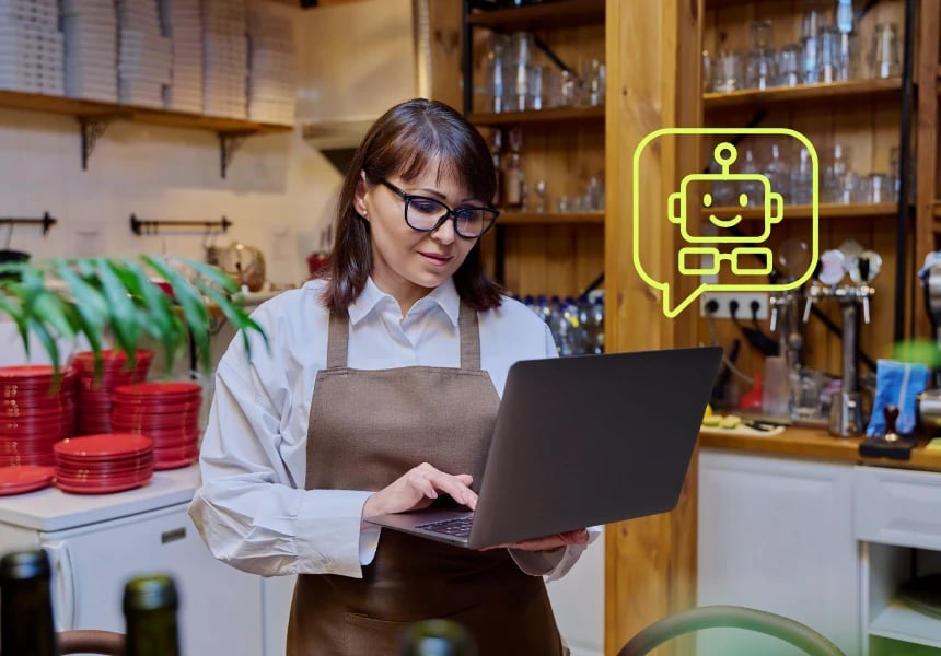 Kvinne jobber på laptop i kafémiljø med AI- og LLM-verktøy for kundeservice og innhold.