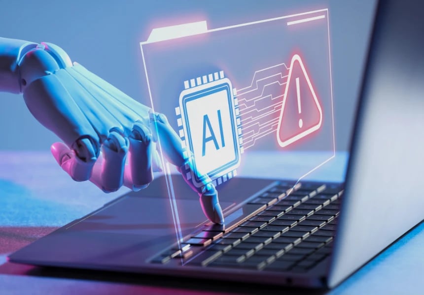 Robottikäsi kannettavalla tietokoneella, jossa on hologrammi, joka esittää tekoälykuvaketta ja punaista varoituskolmiota.